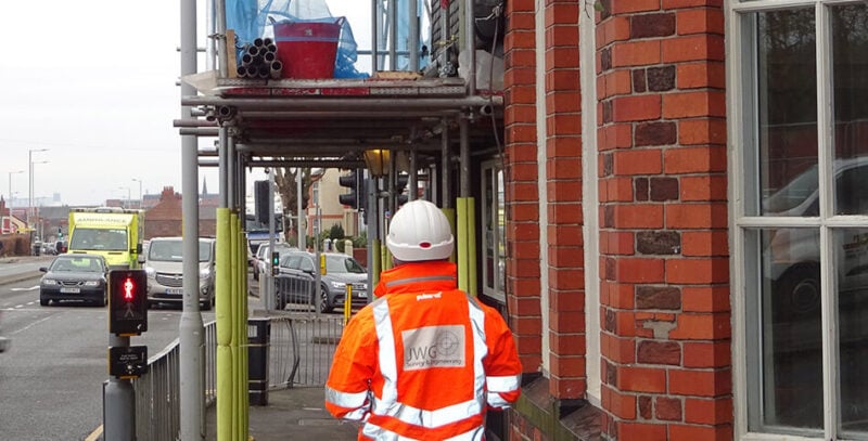 On-site works with a surveyor standing in the street below.